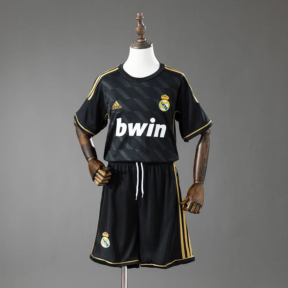 Conjunto infantil del Real Madrid segunda equipación 11/12 negro y dorado - vista frontal