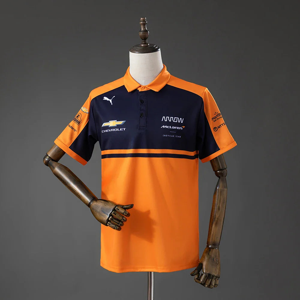 Polo del equipo McLaren de IndyCar 2026 en naranja y azul marino - vista frontal