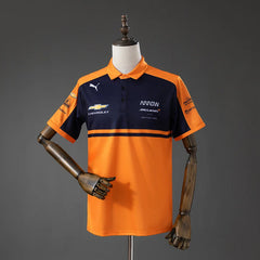 Polo del equipo McLaren de IndyCar 2026 en naranja y azul marino - vista frontal