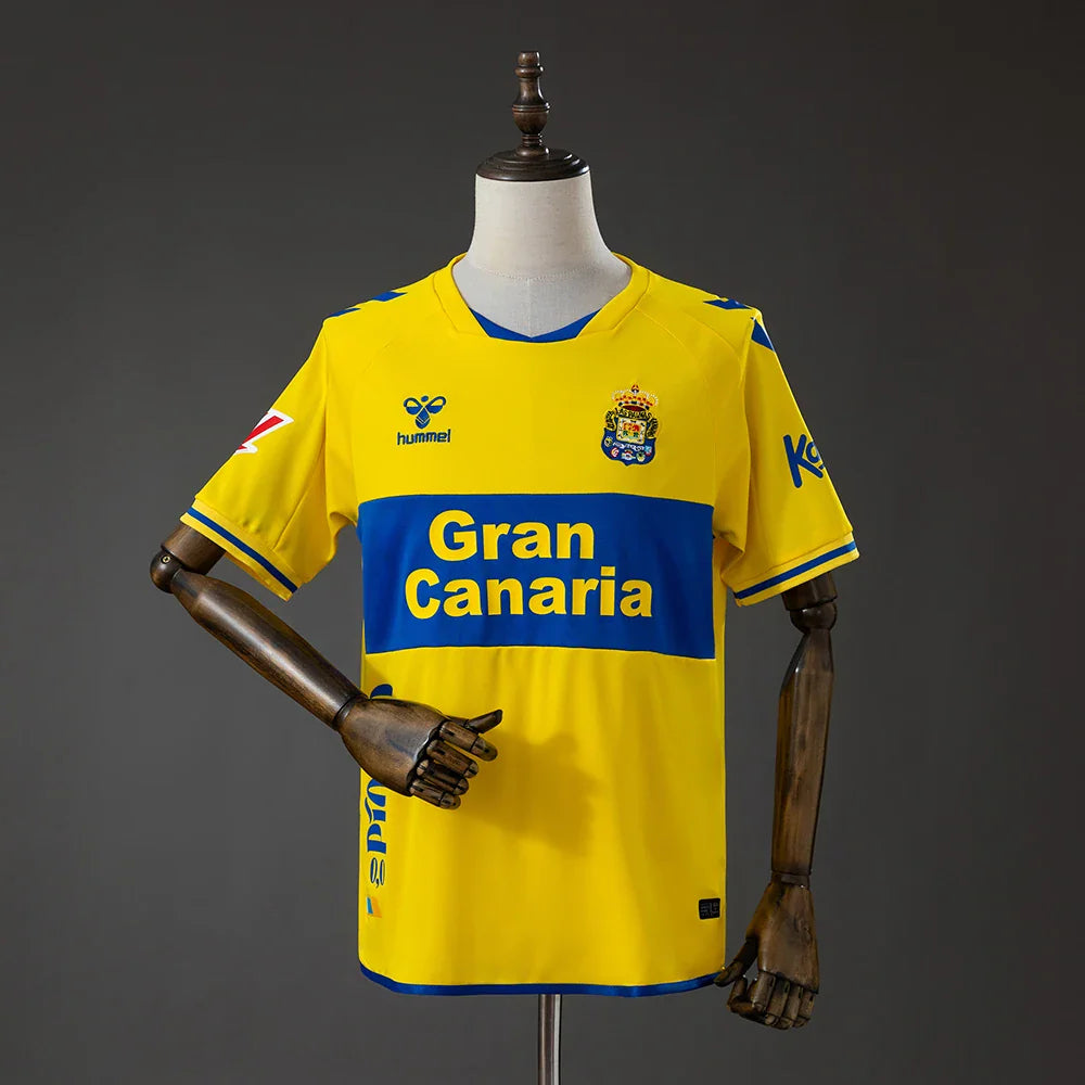 Camiseta de la UD Las Palmas primera equipación 26/27 amarilla con banda azul - vista frontal