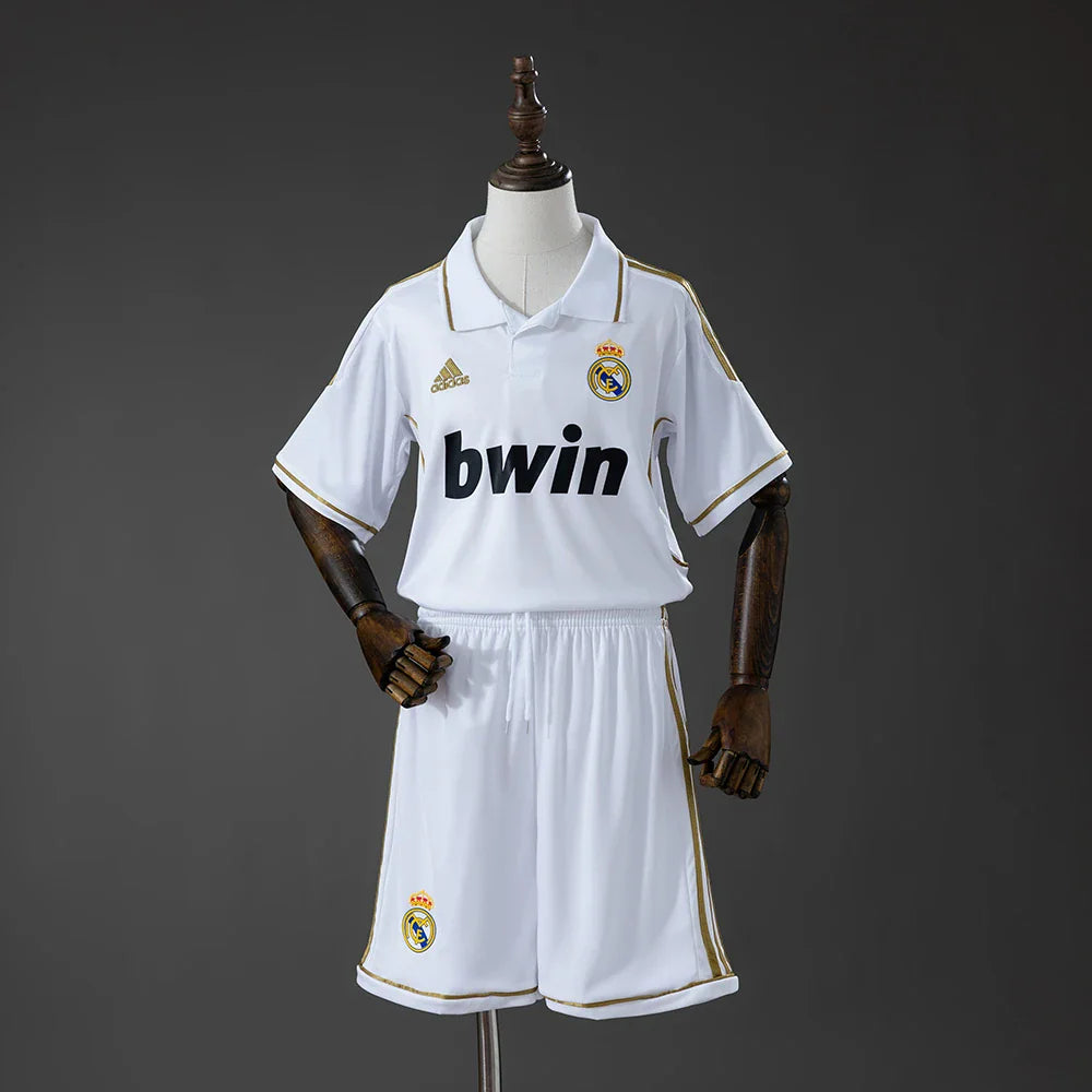 Conjunto infantil del Real Madrid primera equipación 11/12 blanco con cuello polo dorado - vista frontal
